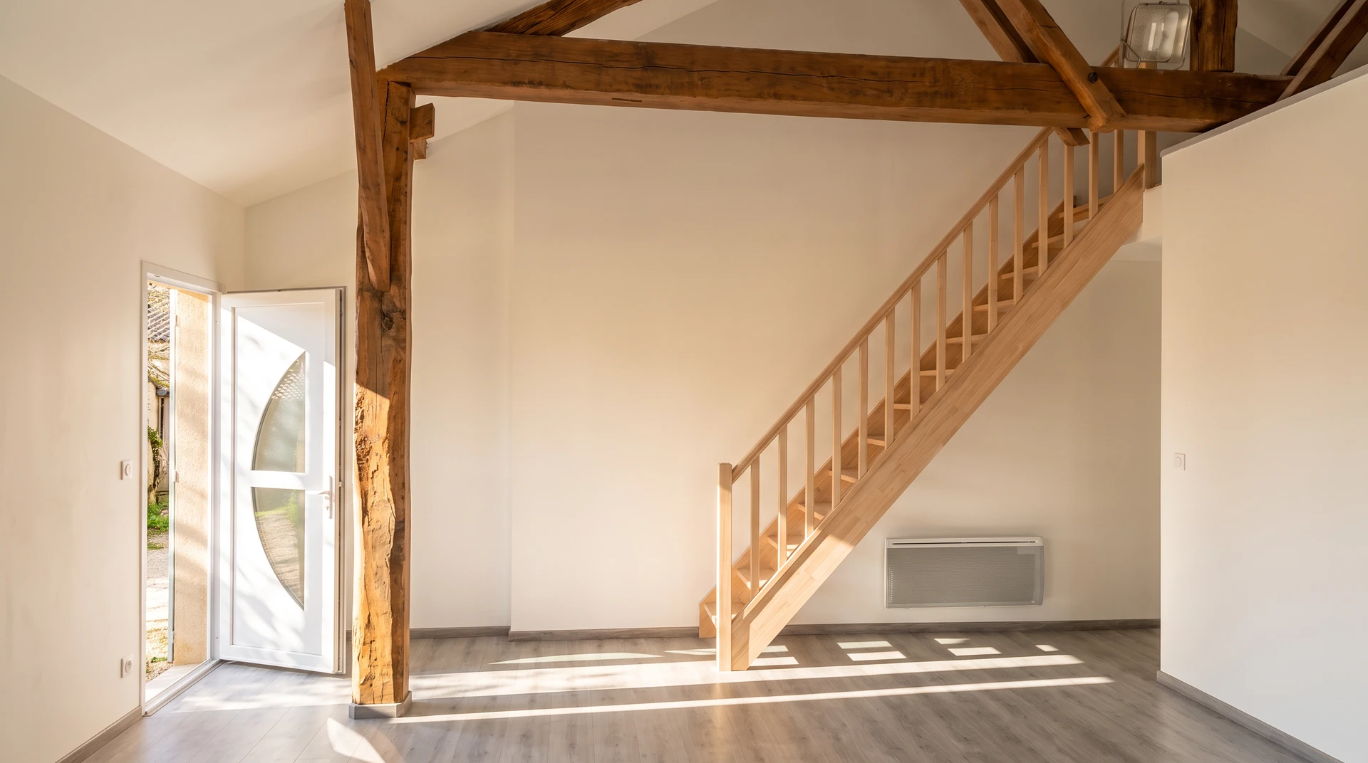 Ouvrier en bâtiment appliquant un enduit de lissage sur mur intérieur avec une taloche inox