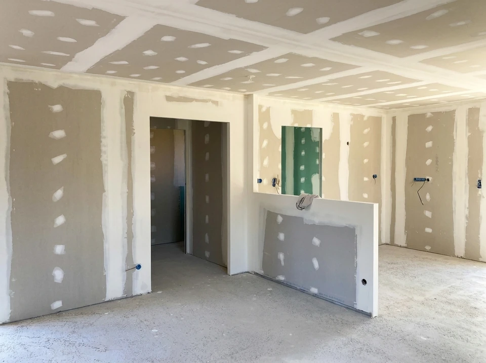 Plafond intérieur avec moulures décoratives en plâtre blanc ornées de motifs floraux et volutes baroques