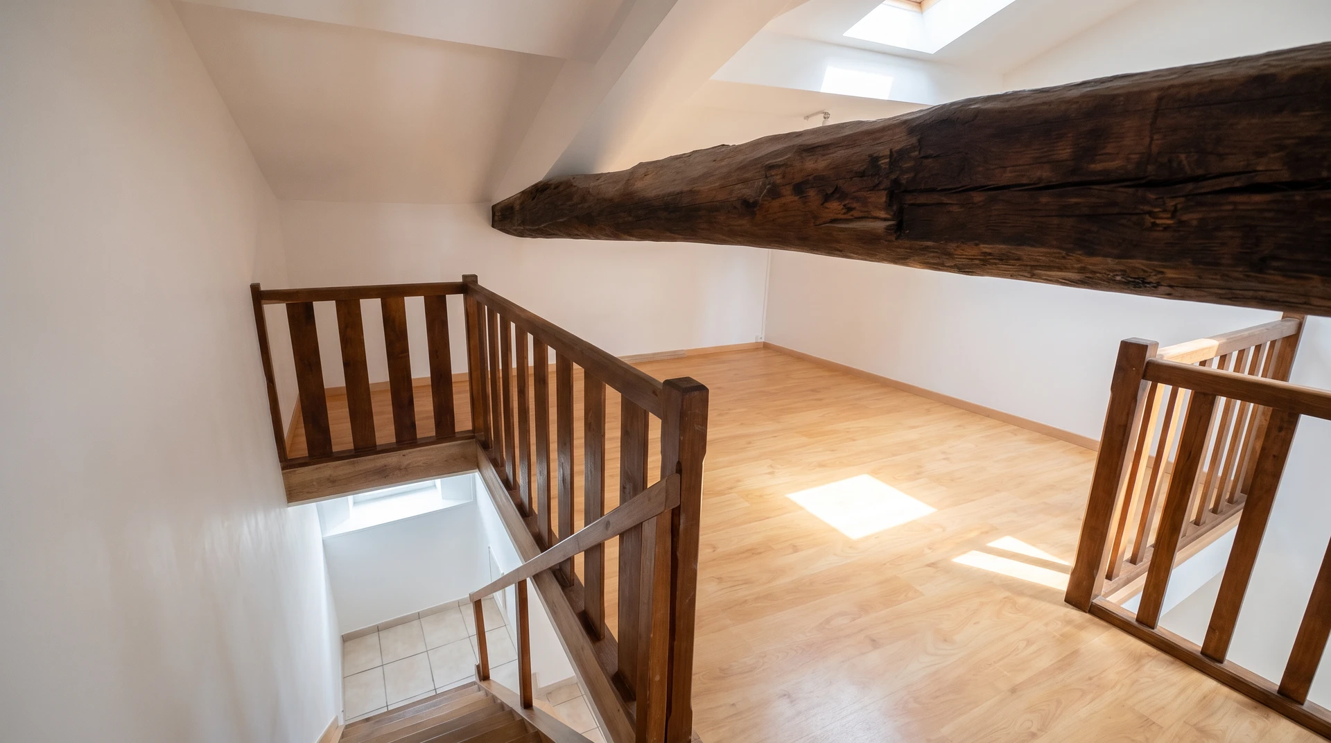 Homme peignant un plafond à l'intérieur d'une pièce, utilisant un rouleau à peinture avec manche télescopique