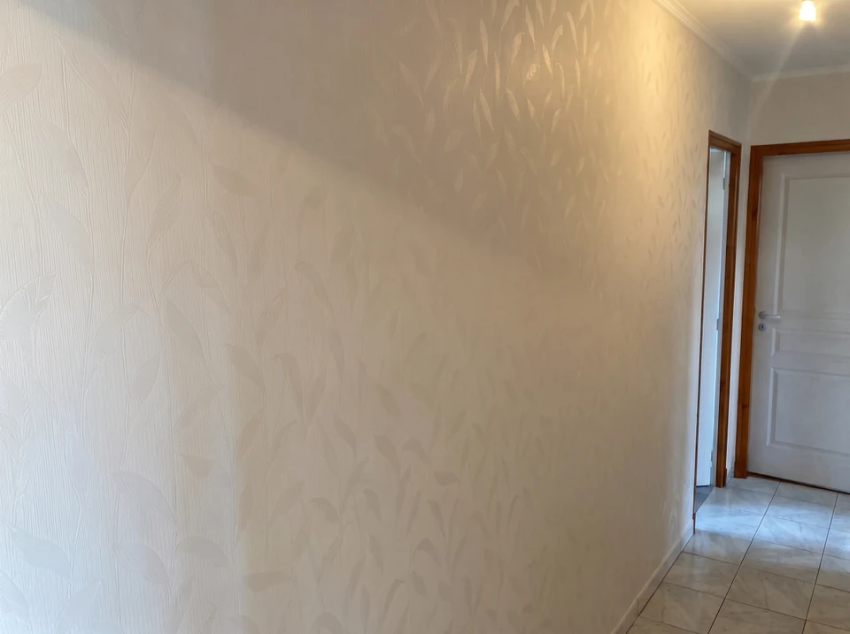 Mur intérieur avec enduit décoratif gris appliqué à la taloche, présentant des motifs texturés et des effets de matière